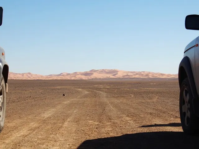 Dirt road leading towards Sahara Desert dunes Morocco